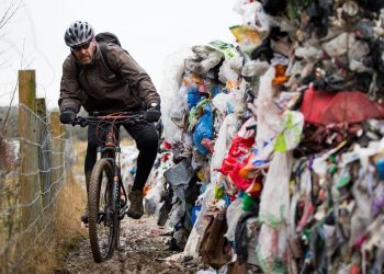 Lee Tanner 49 rides past a mountain of waste such as food products, plastics and paper has been dumped on a cycle path between Biddulph and Brindley Ford, Staffordshire. February 01, 2017. See NTI story NTIRUBBISH; Police are hunting "industrial fly-tippers" who dumped 50 huge blocks of compressed recyclable rubbish at a beauty spot popular with mountain bikers and walkers. Tens of thousands of discarded plastic bottles, bags and cardboard boxes which had been compacted into 10ft-high cubes were left strewn across the path. Cyclists and walkers were forced to squeeze past the stinking piles of trash after they were discovered on the route between Biddulph and Brindley Ford, Staffs., on Saturday (28/1). Staffordshire Police and council officials are now investigating in a bid to find out who dumped the rubbish. Dog-walker David Rowe, 66, who discovered the waste, said: "I walked my dog on Friday night and there was nothing there.