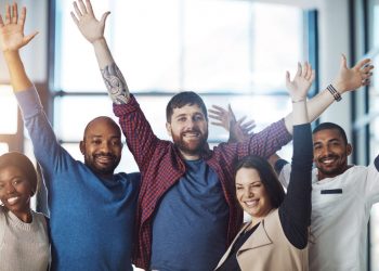 Portrait of a group of young colleagues cheering at work