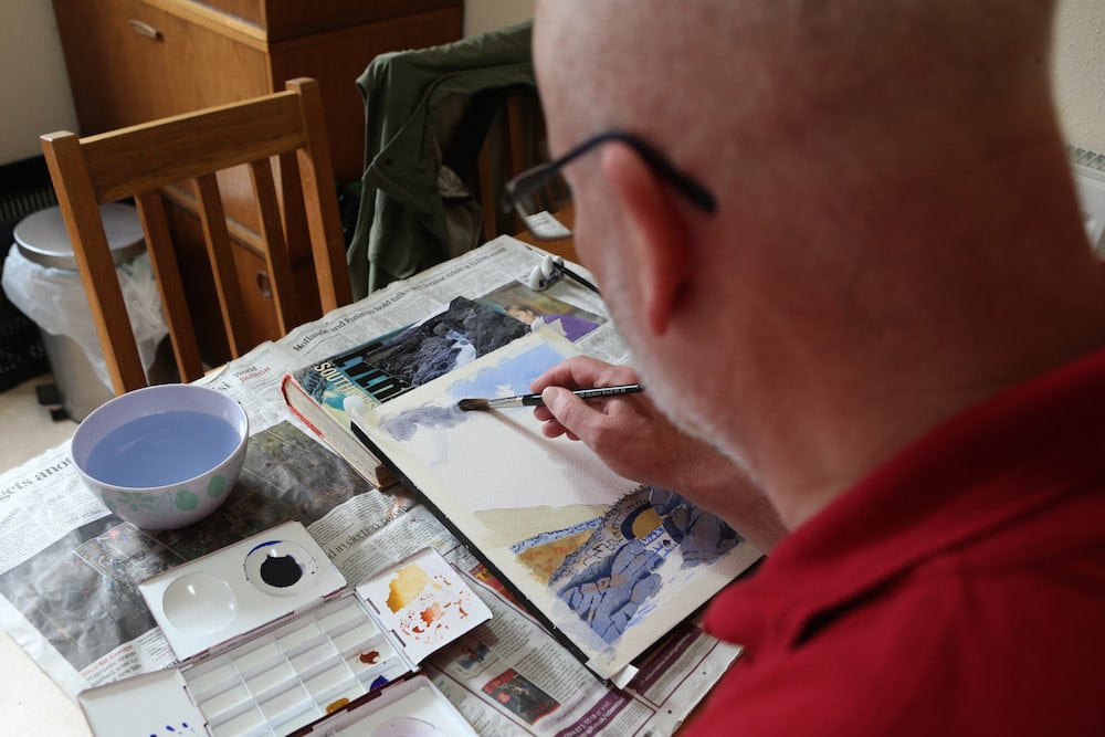Blind artist from Fetcham, Surrey, having an exhibition at Leatherhead Theatre. John Mitchell from Fetcham, Surrey, is an exhibiting artist despite being registered blind as he has tunnel Vision. John Mitchell a talented watercolour artist has learnt to paint stunning landscapes despite being registered blind. See National story NNBLIND; John Mitchell, 58, developed a love for landscapes and geometric shapes in his 30s but was forced to put his canvas down when he developed a mysterious illness. He later developed complete tunnel vision and was recovering from at home on the sofa when he was inspired to brush off the dust on his paintbox. The registered blind artist, who now has no peripheral vision at all, uses a white stick to get around but can see clearly enough to see the colours in front of him. His blindness forces him to paint smaller landscapes and he is unable to draw a straight line.