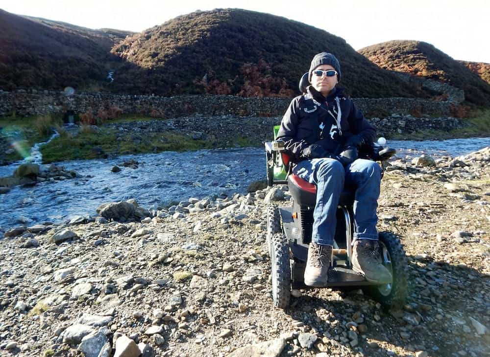 Jason Liversidge from Hull, East Yorks preparing for his latest challenge. He says motor neurone disease is killing him, but wheelchair-bound Jason Liversidge will not let the condition stop him tackling mountains and other challenges. See ROSS PARRY story RPYCLIMB. With the help of his all-terrain 4x4 wheelchair, the Holderness dad of two aims to climb the highest mountain in Wales, Mount Snowdon. Mr Liversidge, 41, is taking on the challenge in a bid to raise £5,000 for Marie Curie Nurses and the Dove House Hospice, Hull. After being diagnosed with the muscle-wasting disease in 2013, Mr Liversidge, 41, from Rise, near Skirlaugh, has lost the ability to move. But the self-confessed adrenaline junkie has not let his condition get in the way of his passion for excitement. He has taken on the longest zip line in Europe at speeds in excess of 100mph, parasailed in Turkey and driven at Silverstone in a Formula One-style racing car. After an online funding campaign to acquire a 4x4 wheelchair, he is now preparing to take on Mt Snowdon on Tuesday, July 18.