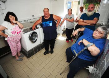 Local residents at Antona Court, Shirehampton, led by Steve Norman (centre). See SWNS story SWWASH; Council legal chiefs are embroiled in a bizarre legal battle after one of its council tenants sued them because they had stopped him washing his clothes after 8pm at night. Residents living in what is a former sheltered housing complex in Shirehampton share a communal laundry, a room which contains two washing machines and two tumble dryers.That room in Antona Court, in the shadow of the M5 approach to the Avonmouth Bridge, was always open whenever residents needed to go there, 24 hours a day.