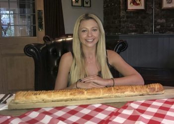 Kate Ovens begins her challenge to eat a saugsauge roll which is - three feet long. See National news story NNROLL; A woman has taken on Britain's biggest sausage roll - measuring a massive 3FT and so big it needs to be served on a FENCE POST. Famous challenge eater Kate Ovens managed to polish off most of the giant snack in just TEN minutes. But the 23-year-old feared she had met her match with the 3750-calorie snack - because she hit 'the wall' with less than six inches of the meaty treat left. The 5ft 5ins eating machine went for a tactical walk for about ten minutes in a bid to free up some more room.