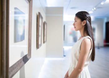 pretty young chinese girl, alone in the museum visit china painting exhibition.