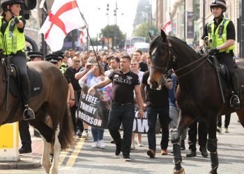 Around 400 Tommy Robinson supporters turned marched today to protest the jailing of the English Defence League (EDL) founder. One supporter threw a red flare on top of the court building and a Dr Pepper bottle was thrown at a police officer. Despite Tommy Robinson admitting contempt of court last Friday in breaching a temporary reporting restriction put in place to allow related cases not to be jepoardised, 400 of his fans brandished '#FreeTommy' placards.