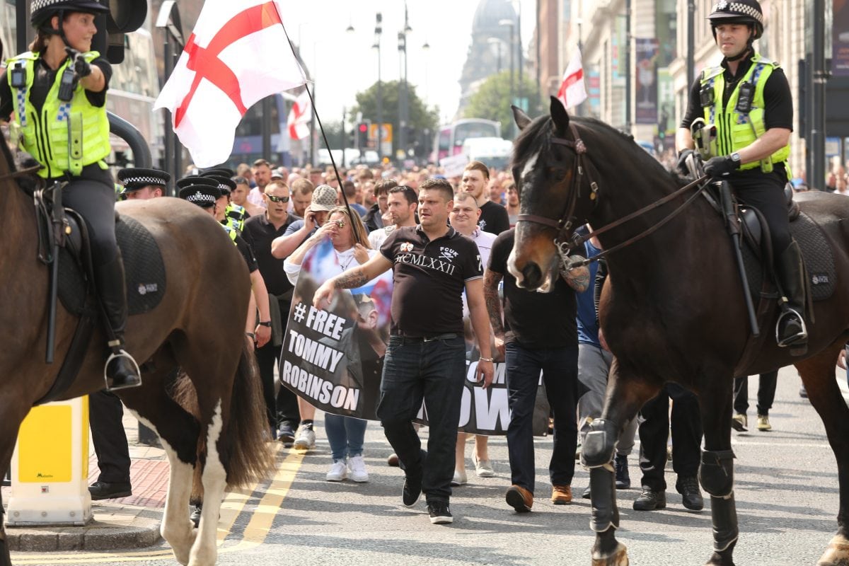Around 400 Tommy Robinson supporters turned marched today to protest the jailing of the English Defence League (EDL) founder. One supporter threw a red flare on top of the court building and a Dr Pepper bottle was thrown at a police officer. Despite Tommy Robinson admitting contempt of court last Friday in breaching a temporary reporting restriction put in place to allow related cases not to be jepoardised, 400 of his fans brandished '#FreeTommy' placards.