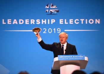 Johnson waves a kipper at Tory leadership hustings to make a point about EU regulations (PA)