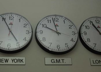 A row of clocks showing the time in different time zones such as New York and London.