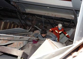 A man is assisted out from the rubble of a collapsed hotel building in Quanzhou city in southeast China's Fujian province Saturday, March 07, 2020. The hotel used for medical observation of people who had contact with coronavirus patients collapsed in southeastern China on Saturday, trapping dozens, state media reported. (Chinatopix via AP)