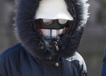 A woman wearing a protective face mask walks along the Royal Mile, Edinburgh, as the Government's top scientist warmed that up to 10,000 people in the UK are already infected.