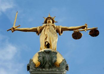 View of the gold statue of the figure of justice, holding scales and a sword, on top of the Central Criminal Court, also referred to as Old Bailey, in central London.
