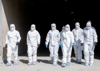 File photo of a Covid19 drive through testing station in Gdansk, Poland. The PPE being worn by the testers is body suit, face visor, respirator, fett coverings and gloves. See SWNS story SWOCppe A comparison with pictures from other country's drive through testing stations seems to indicate that PPE standards in the UK offer less protection.