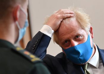 Prime Minister Boris Johnson, wearing a face mask, talks with a paramedic during a visit to the headquarters of the London Ambulance Service NHS Trust.