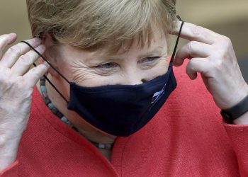German Chancellor Angela Merkel adjusts her face mask as she arrives for a meeting of the upper house of the German legislative in Berlin, Germany, Friday, July 3, 2020. (AP Photo/Michael Sohn)