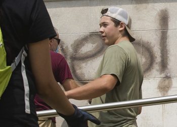 Kyle Rittenhouse helps clean the exterior of Reuther Central High School in Kenosha, Wis., on Tuesday, Aug. 25, 2020. Rittenhouse, 17, was arrested Wednesday, Aug. 26, after two people were shot to death during protests in Kenosha over the police shooting of Jacob Blake. (Pat Nabong/Chicago Sun-Times via AP)