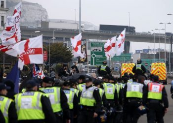 Police officers march with far-right protesters though Dover in Kent as they demonstrate against the arrival of immigrants in 2016 Credit;PA