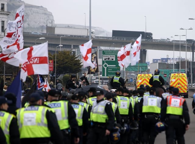 Police officers march with far-right protesters though Dover in Kent as they demonstrate against the arrival of immigrants in 2016 Credit;PA