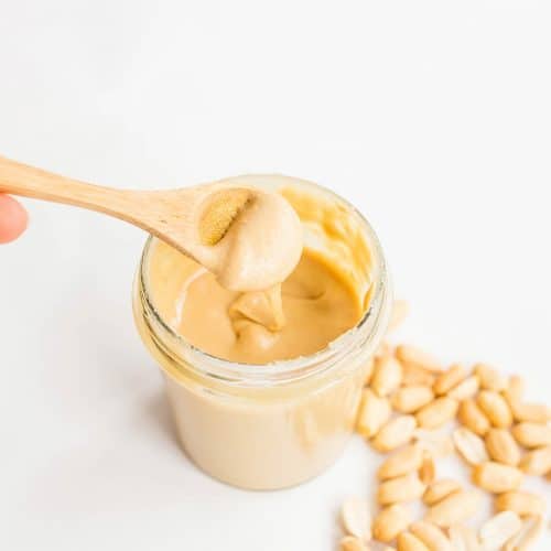Homemade peanut butter in glass jar with hand and wooden spoon Photo: Marco Verch Professional Photographer / Flickr