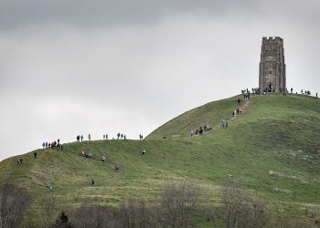 People walk up to St Michael's Tower on the top of Glastonbury Tor, Somerset, as forecasters have warned of treacherous driving conditions for Easter holidaymakers with snow and torrential rain on the way.