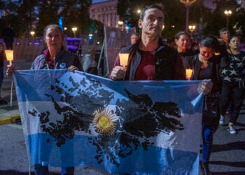 BUENOS AIRES, ARGENTINA - APRIL 02: A Malvinas war veteran and a woman hold an Argentinian flag with the Malvinas Islans drawed on April 2, 2022 in Buenos Aires, Argentina. Argentina commemorates the Argentine soldiers fallen during the Guerra de las Malvinas/Falklands Islands War on the 40th anniversary since the start of conflict against Great Britain over the sovereignty of the islands. (Photo by Ricardo Ceppi/Getty Images)